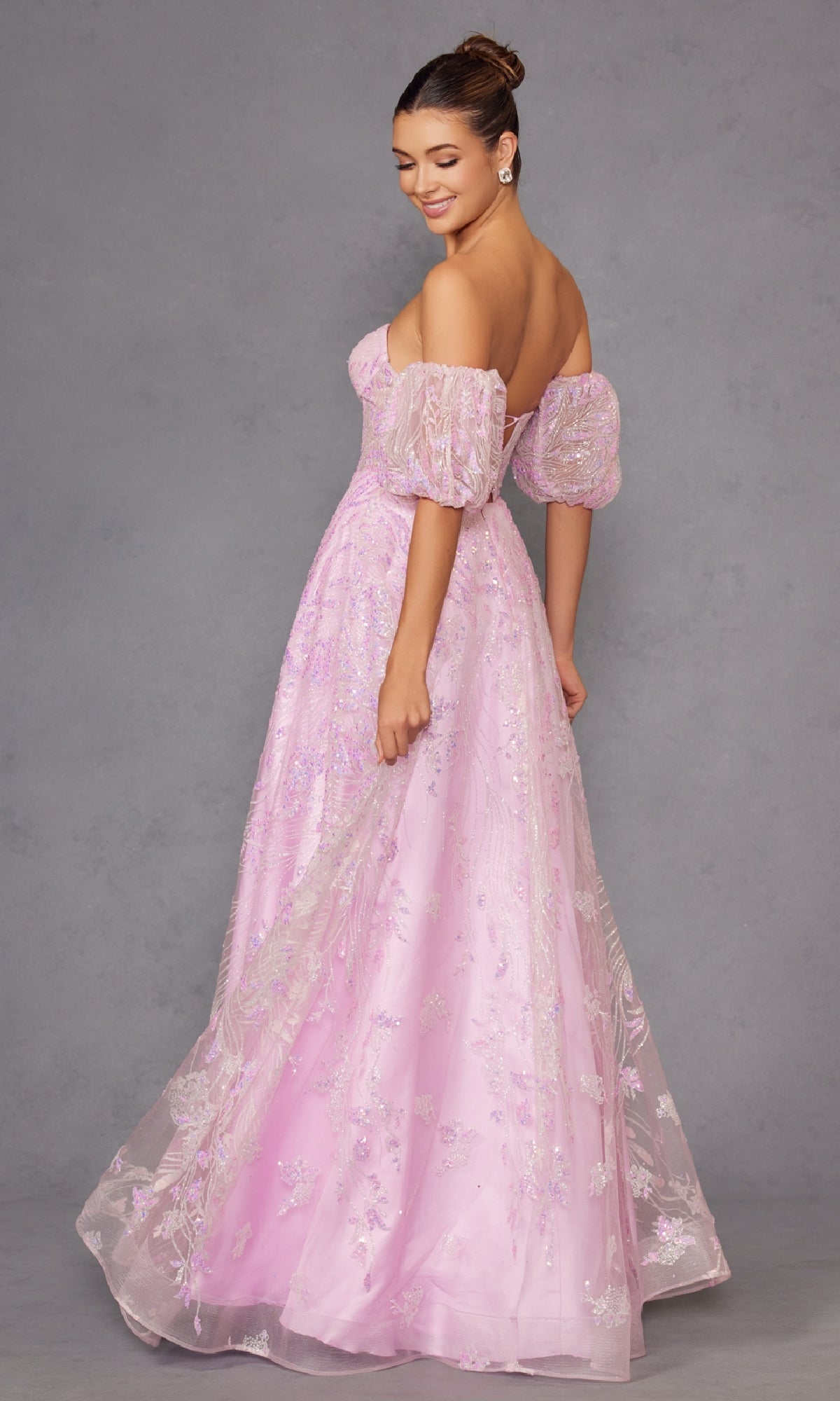 A woman wearing the Puff-Sleeve Strapless Long Glitter Prom Dress 2404 poses against a plain gray background, looking over her shoulder.